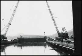 Lifting basin gate with cranes