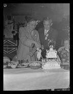 Mrs. Jim Bell and Mayor N.S. Johnson cutting Enderby anniversary cake