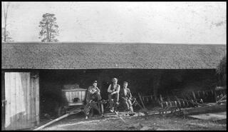 Men at implement shed at Swan Lake