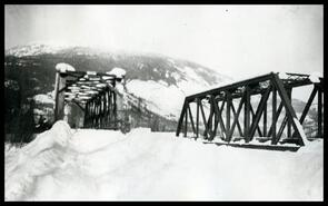 Snow-covered rail and traffic bridge over Illecillewaet River