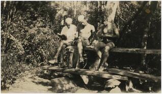 Three Boy Scouts out of uniform sitting on a bench at Chute Creek