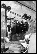 Miners riding up aerial tramway at Base Metal Mine