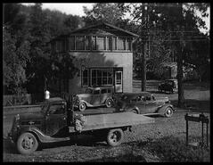 Mr. Gleed's Store with automobiles and truck in the foreground