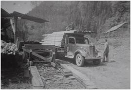 Two men loading lumber from Bruhn Sawmill onto 34' Ford truck