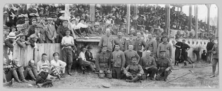 Soldiers in group photograph in front of grandstand at fairgrounds