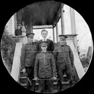 James P. Schofield and friends in uniform standing on porch steps