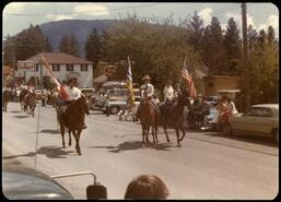 Eddie King and others with flags leading Falkland Stampede parade on horseback