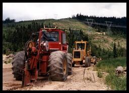 Heavy equipment digging narrow trench for Okanagan Telephone lines