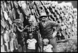 Jacob and Jennie Allen with grandchildren Lloyd and Ronald Richardson at log pile