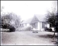 View of garden with a white picket fence and partial unidentified house
