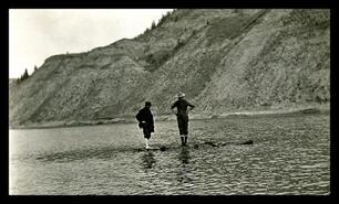 Men standing in lake, unknown location