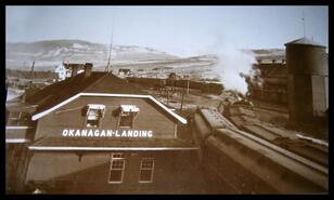 Train station at Okanagan Landing with box cars and water tower