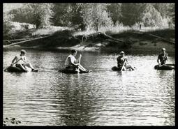 Boys floating down the river on inner tubes