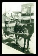 Georgie and Kent Nixon on an old cart Charlie used to deliver produce from the meat market