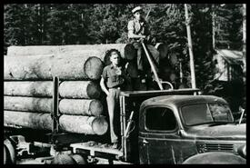 Sam Conkin holding a peeve next to unidentified man on a Cady Lumber Co. logging truck
