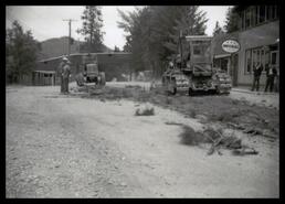 Tractor and grader working on road in front of the store in Okanagan Centre