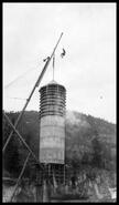 Putting a flag on the surge tower at Shuswap Falls dam construction