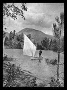 Man in a sailboat near the shore of Okanagan Lake