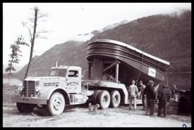 Y2 tugboat on back of Amow truck being lowered into lake