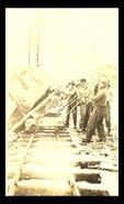 Men tipping rock off railcar