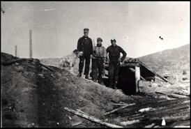 Three men and dog at entrance to Coal Hill Mine