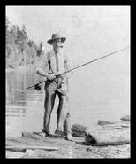 Unidentified man with fish on the shore of Okanagan Lake
