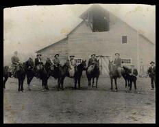 Group of men on horseback in front of the Casorso barn