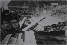 Russell Waterson piling white pine planks at Bruhn Sawmill in Old Town Bay