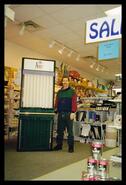 Unidentified man in store beside a curtain display