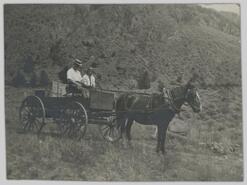 Man and women in horse-drawn wagon
