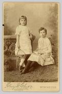 Two unidentified children, each holding props