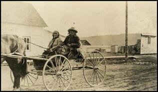 Tattley and wife sitting in backboard of wagon, Athalmer