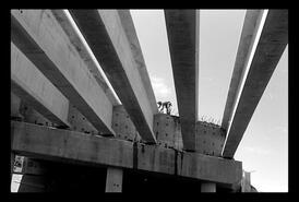 Construction worker on highway overpass beams