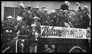 1961 World champion Smokies on fire truck in parade with Kromm holding trophy