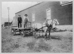 Two unidentified men with horses and wagon