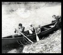 Group (possibly Scouts) launching canoe into river
