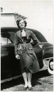 Catherine Lake in Girl Guide uniform standing beside automobile