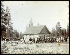 Group of horsemen and families standing outside North Kettle River School