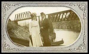 Unidentified man and a woman in front of the Great Northern Railway bridge at smelter dam