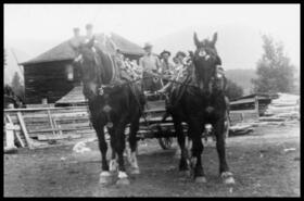 Horse team pulling a wagon with four passengers