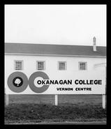 Okanagan College Vernon Centre sign in front of one of the Vernon Army Camp huts
