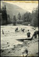 Men clearing debris from flooded river