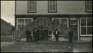 Group of men with pelts hanging in front of Joe Lake's store