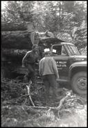 Two men beside loaded logging truck