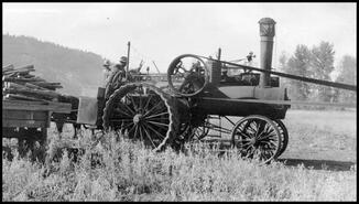 Steam tractor driving thresher