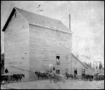 Horse-drawn wagons in front of the Vernon Grist Mill