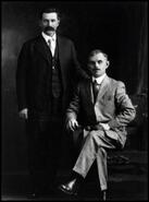 George Meeres seated on chair with unidentified man