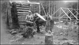 Joe Miska and Lloyd Bertram constructing a log building