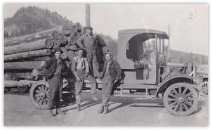 Men posing with logging truck