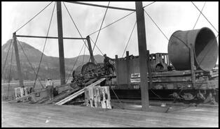 Unloading mining machinery from a barge at the C.P.R. wharf at Ewings Landing
